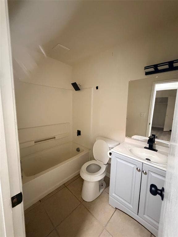 Tile flooring, white vanity with cabinet storage, integrated sink, black faucet, and overhead light bar