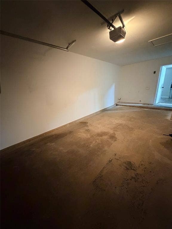 Concrete flooring with an automatic garage door opener and overhead lighting