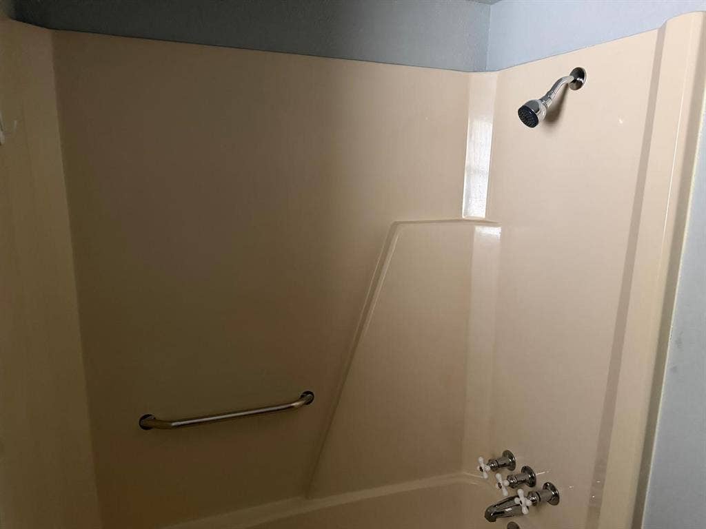 2928 Almeta Lane, McKinney, TX 75069 Integrated tub and shower unit with a chrome shower head, chrome faucet, and a wall-mounted grab bar
