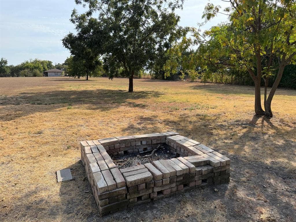 2928 Almeta Lane, McKinney, TX 75069 Rectangular brick fire pit feature with expansive outdoor space and mature trees
