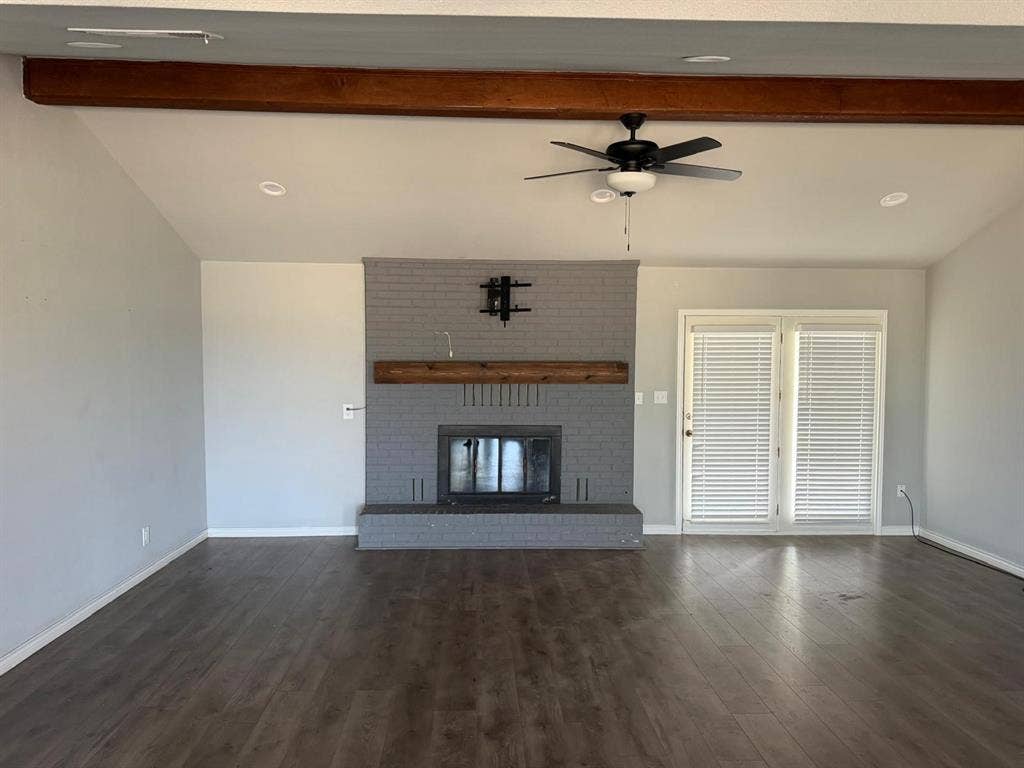 2928 Almeta Lane, McKinney, TX 75069 Spacious living area featuring wood-finish flooring, a painted brick fireplace with a wood mantle, exposed wood beams, a ceiling fan, and recessed lighting