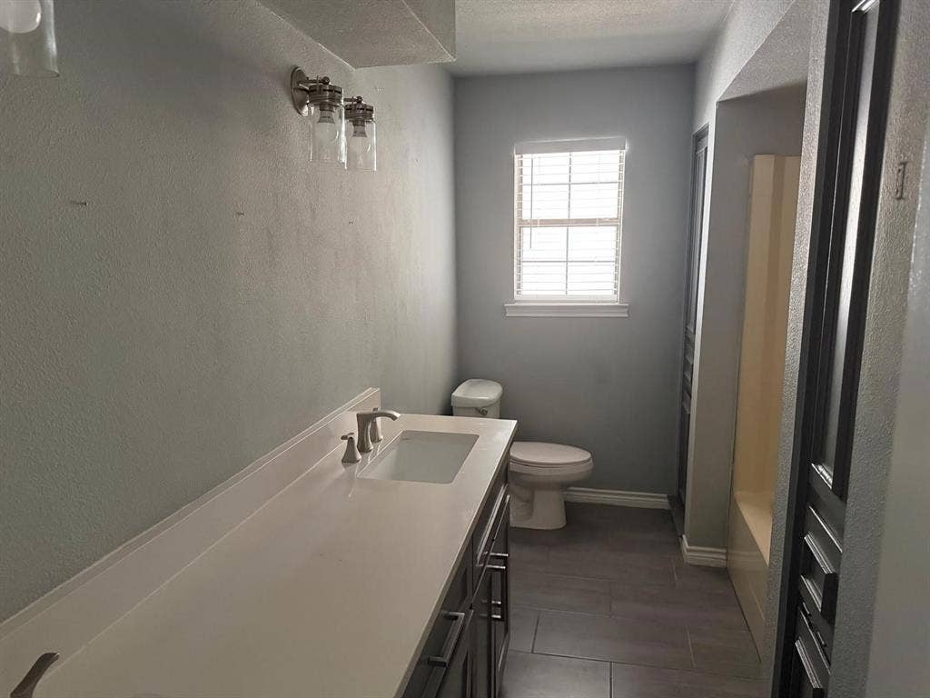 2928 Almeta Lane, McKinney, TX 75069 Vanity with integrated sink, brushed nickel faucet, and a window with horizontal blinds