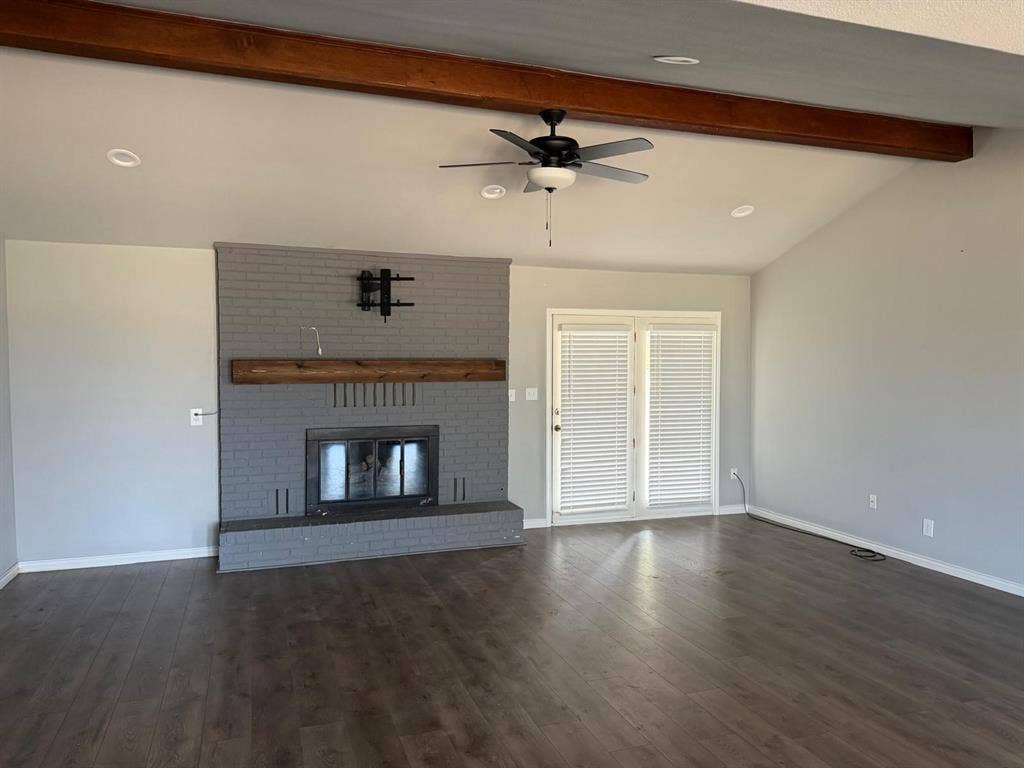 2928 Almeta Lane, McKinney, TX 75069 Vaulted ceiling with exposed wood-finish beam, brick fireplace with wood-finish mantel, wood-finish flooring, and double French doors
