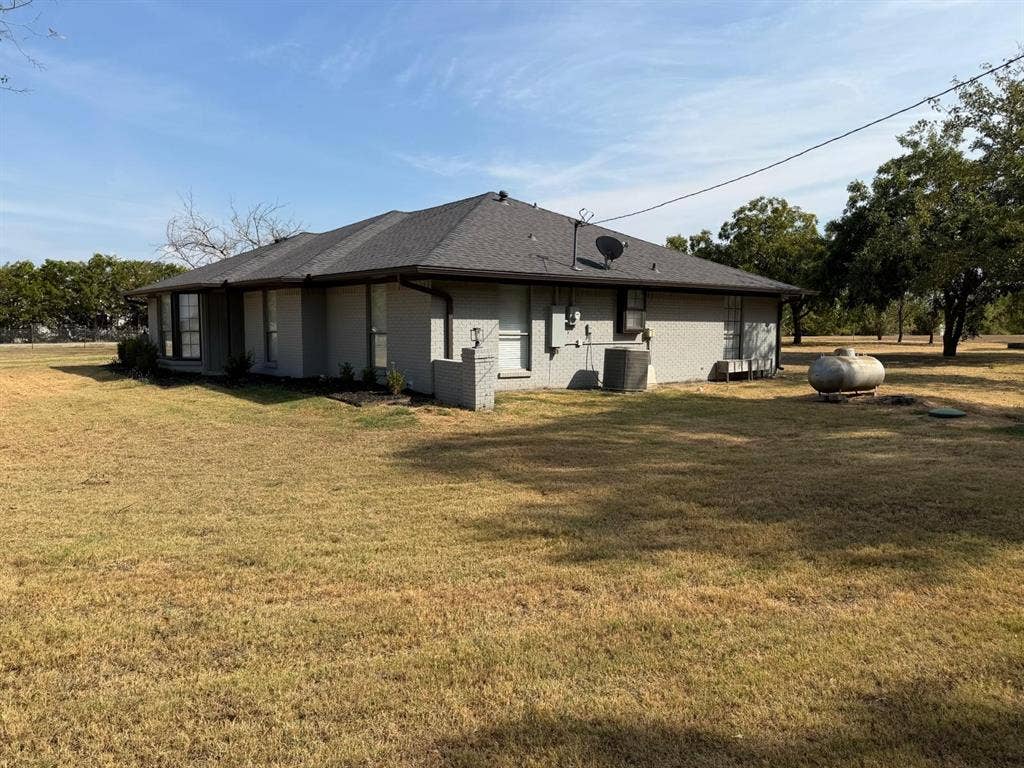 2928 Almeta Lane, McKinney, TX 75069 Single-story exterior with a dark shingle roof, light-colored brick siding, and an expansive yard