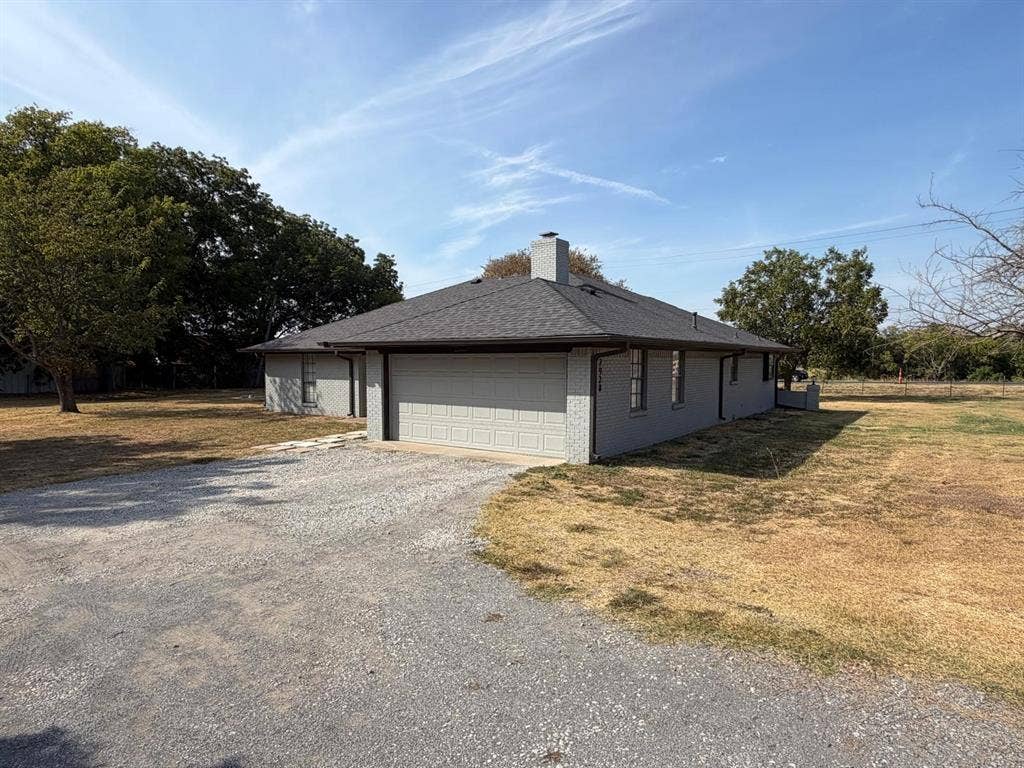 2928 Almeta Lane, McKinney, TX 75069 Gray brick exterior with a dark shingle roof and an attached garage