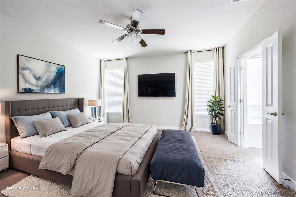 1548 Seabiscuit Drive, Granbury, TX 76049 Wall-mounted television, ceiling fan with light fixture, window with blinds and drapes, and double doors