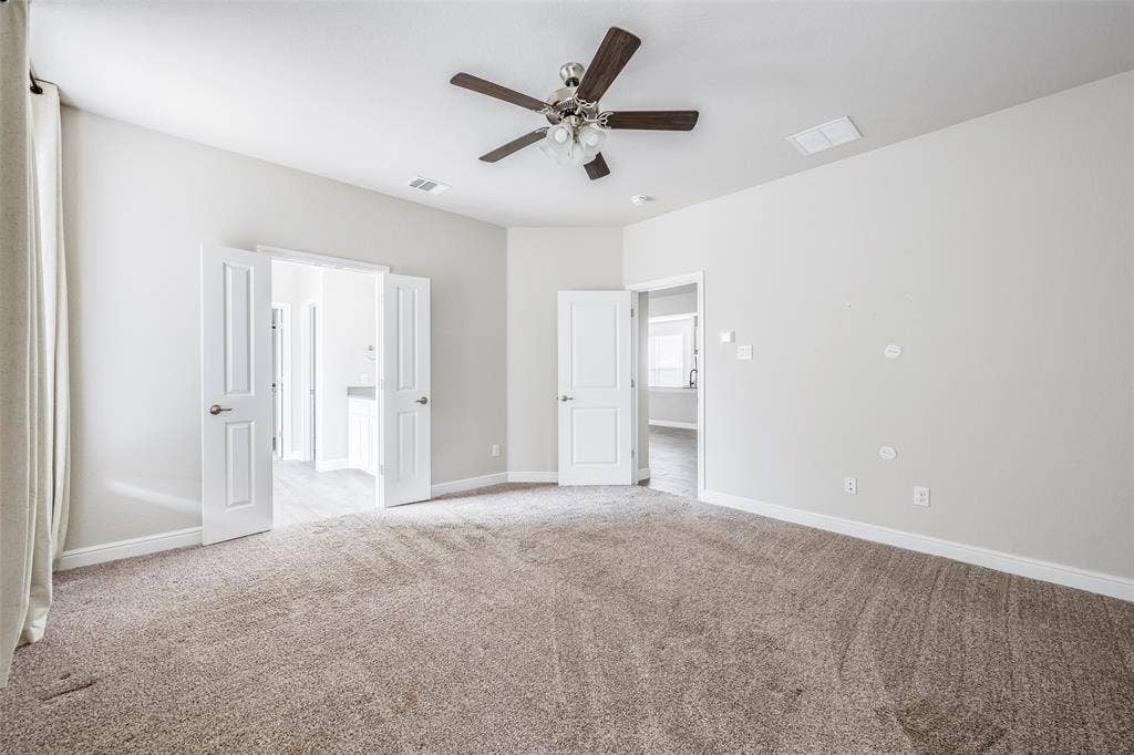 1548 Seabiscuit Drive, Granbury, TX 76049 Neutral tone walls, ceiling fan with wood-finish blades, carpeted flooring, and white paneled doors