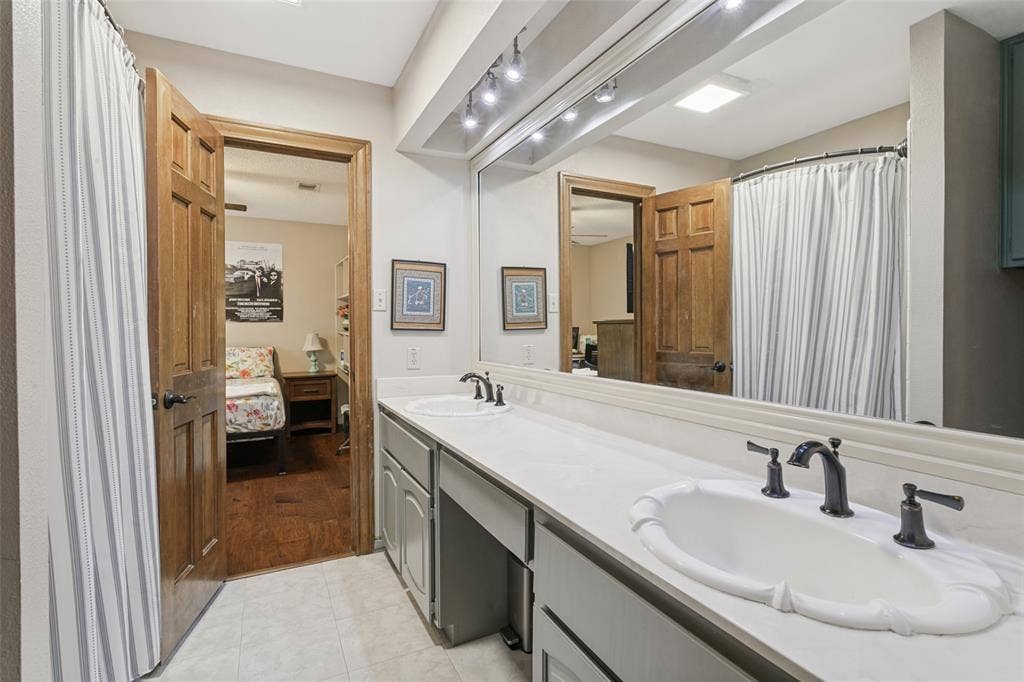 6801 Bellaire Court S, Benbrook, TX 76132 Dual vanity featuring undermount sinks, bronze finish fixtures, and integrated countertop