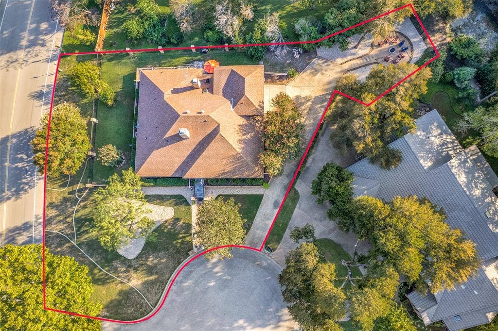 6801 Bellaire Court S, Benbrook, TX 76132 Expansive property featuring a multi-gabled roofline, mature trees, a paved driveway, and a distinct outdoor patio area