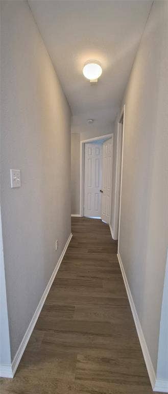 7403 Stone Hearth Drive, Frisco, TX 75035 Hallway featuring wood-finish flooring, white baseboards, and a flush-mount ceiling light fixture