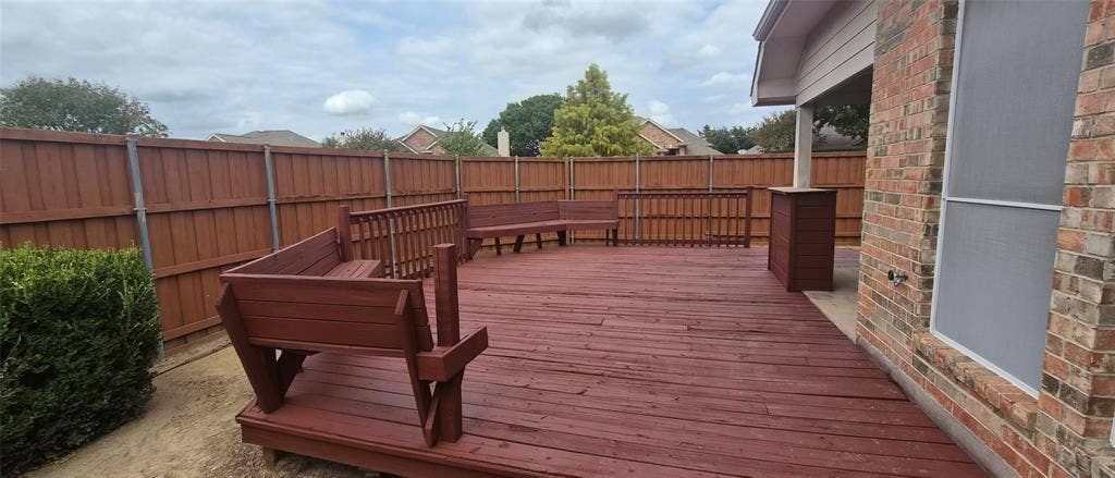7403 Stone Hearth Drive, Frisco, TX 75035 Expansive wood deck with built-in bench seating, privacy fencing, and brick exterior