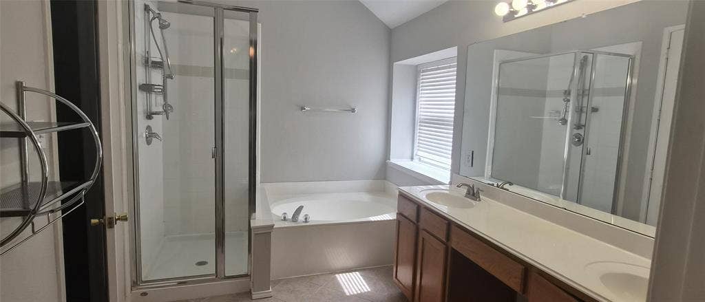 7403 Stone Hearth Drive, Frisco, TX 75035 Integrated shower with glass enclosure, built-in soaking tub, dual vanity with undermount sinks, wood-finish cabinetry, and overhead lighting