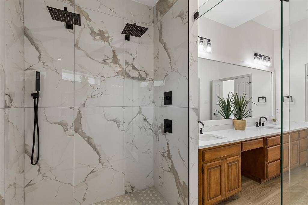 1503 Milla Court, Euless, TX 76039 Walk-in shower with dual matte black rainfall showerheads and a handheld sprayer