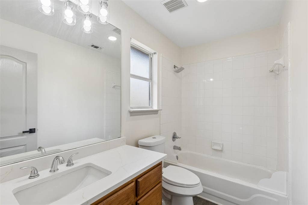 1503 Milla Court, Euless, TX 76039 White-tiled bath and shower combination with a built-in soap dish