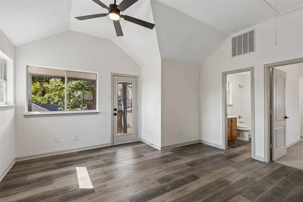 1503 Milla Court, Euless, TX 76039 Vaulted ceiling with a ceiling fan, wood-finish flooring, a window with exterior scenery, a glass-paned door, and white walls