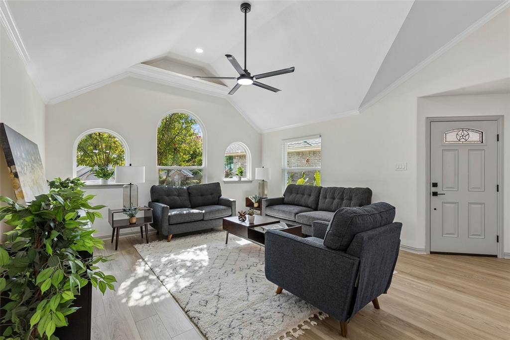 1503 Milla Court, Euless, TX 76039 Vaulted ceilings with a ceiling fan, three arched windows, wood-finish flooring, and a paneled entry door with decorative glass