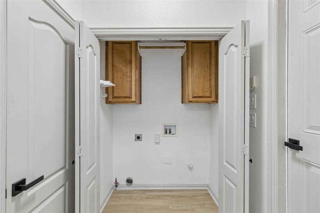 1503 Milla Court, Euless, TX 76039 Dedicated laundry area featuring wood-finish flooring, white walls, and wood cabinetry
