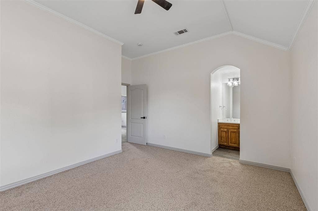 1503 Milla Court, Euless, TX 76039 Vaulted ceiling, carpet flooring, arched doorway, wood-finish vanity, and ceiling fan