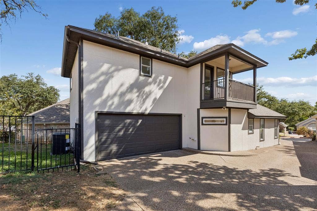 1503 Milla Court, Euless, TX 76039 Stucco exterior with a balcony, dark trim, an attached garage, and a wrought iron fence