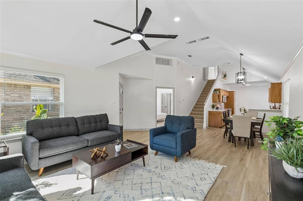 1503 Milla Court, Euless, TX 76039 Open-concept living space featuring vaulted ceilings, wood-finish flooring, a modern ceiling fan, and a dining area with pendant lighting