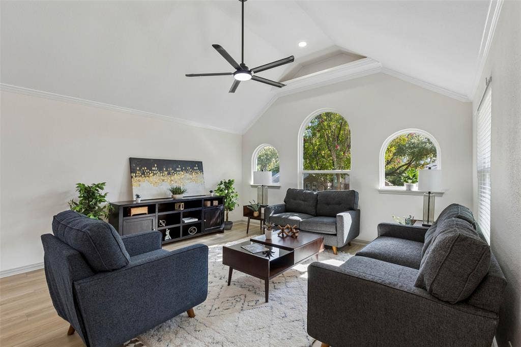 1503 Milla Court, Euless, TX 76039 Vaulted ceiling with a contemporary ceiling fan, multiple arched windows, crown molding, and wood-finish flooring