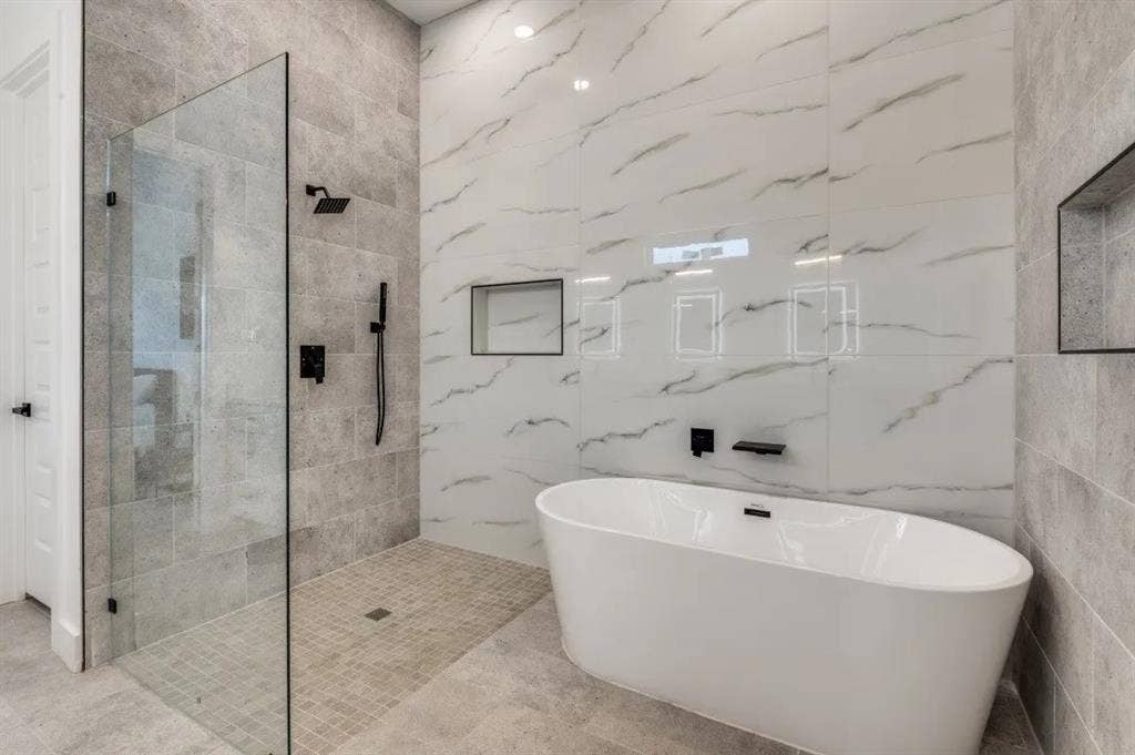 2806 Guymon Street, Dallas, TX 75212 Freestanding soaking tub, walk-in shower with glass enclosure, matte black fixtures, recessed shower niche, and large format wall tile