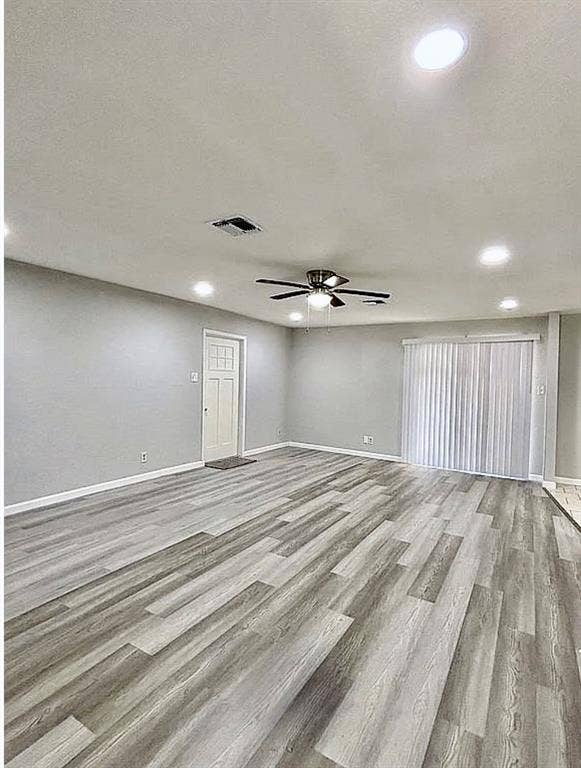 2115 N 9th Street, Temple, TX 76501 Spacious room featuring wood-finish flooring, recessed lighting, a ceiling fan, and vertical blinds