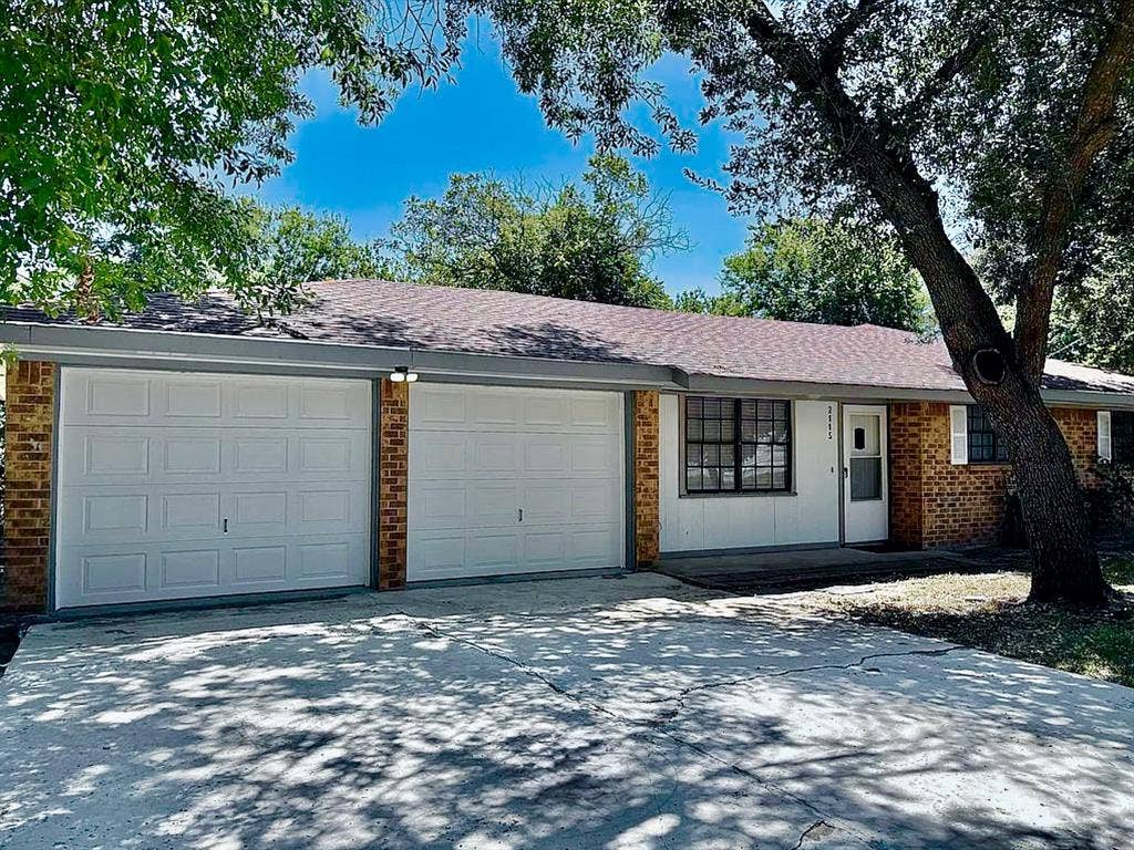 2115 N 9th Street, Temple, TX 76501 Brick exterior with a dual garage, a gabled roof, and a concrete driveway