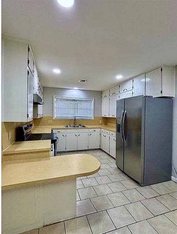2115 N 9th Street, Temple, TX 76501 Kitchen featuring light-toned tile flooring, white cabinetry, a double-basin stainless steel sink, and light-toned countertops