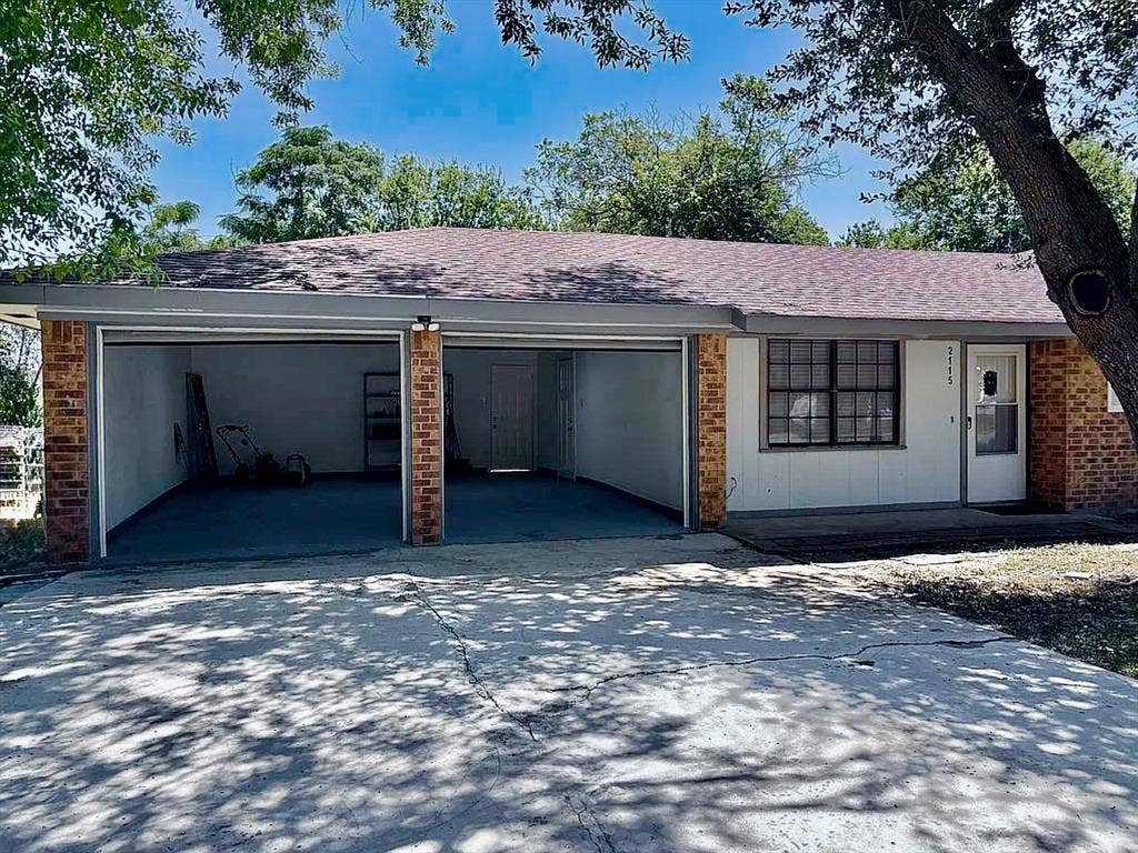 2115 N 9th Street, Temple, TX 76501 Brick and siding exterior with a two-car garage, concrete driveway, and front entry