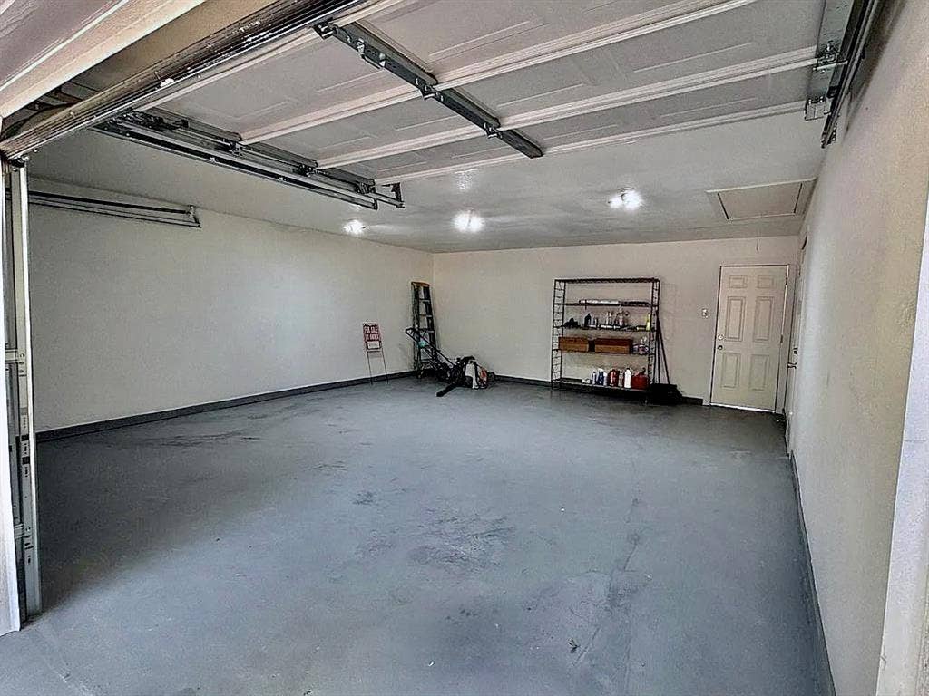 2115 N 9th Street, Temple, TX 76501 Attached garage with an overhead door, finished walls, and a dedicated entry door