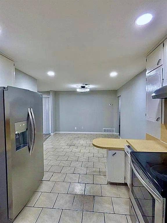 2115 N 9th Street, Temple, TX 76501 Kitchen featuring tile flooring, white cabinetry, light-toned countertops, and stainless steel appliances