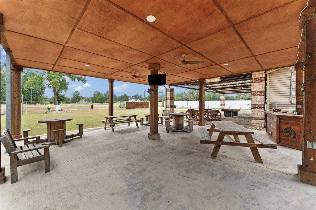 5989 State Highway 31 E, Murchison, TX 75778 Expansive covered patio featuring a concrete floor, wood-paneled ceiling, recessed lighting, and ceiling fans