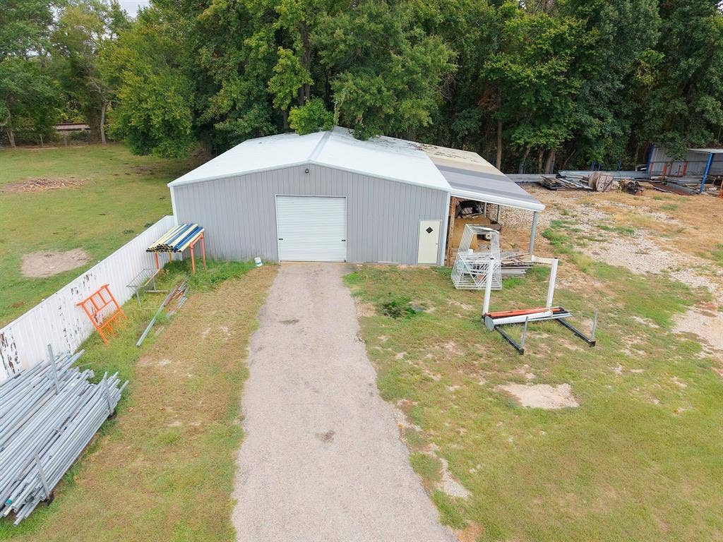 5989 State Highway 31 E, Murchison, TX 75778 Metal-sided building with a white overhead door and a covered side entrance