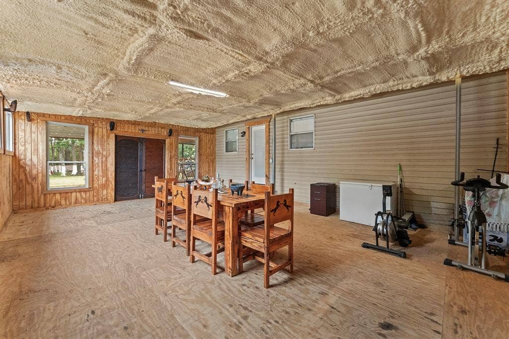 5989 State Highway 31 E, Murchison, TX 75778 Expansive room with plywood flooring, wood-paneled walls, and a textured ceiling
