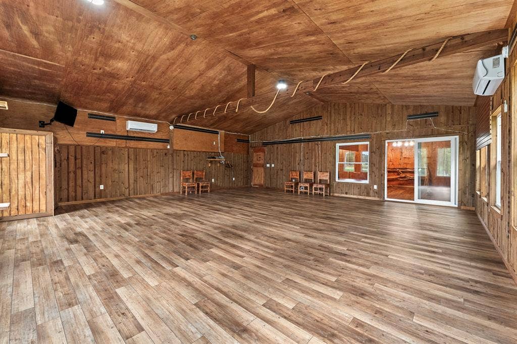 5989 State Highway 31 E, Murchison, TX 75778 Vaulted wood-paneled ceiling, wood-finish flooring, wood-paneled walls, sliding glass door, multiple fixed windows