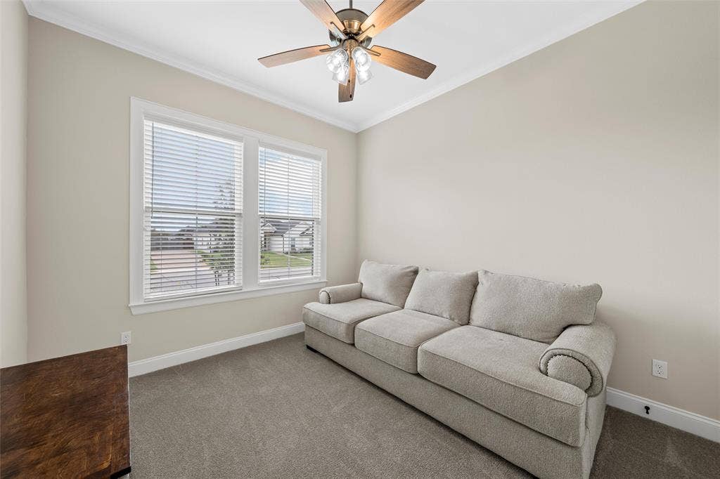 10201 Castleberry Lane, Waco, TX 76712 Carpeted room featuring dual windows with blinds, a ceiling fan with light fixture, and crown molding