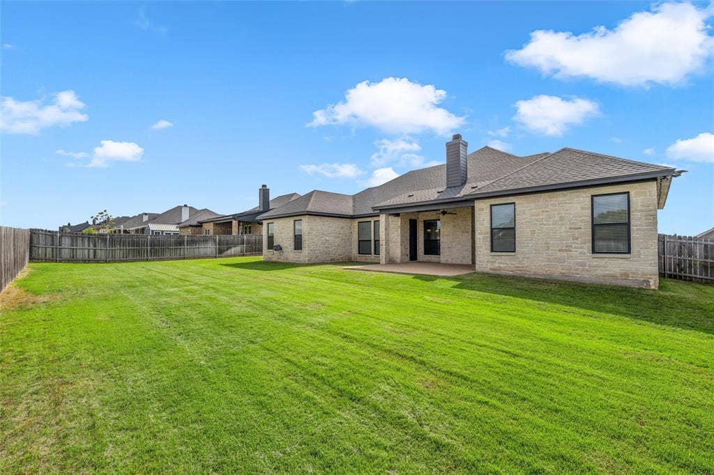 10201 Castleberry Lane, Waco, TX 76712 Expansive backyard featuring a lush lawn, privacy fencing, and a covered patio