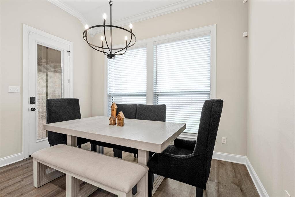10201 Castleberry Lane, Waco, TX 76712 Hardwood-style flooring, crown molding, double pane windows with blinds, and a built-in chandelier