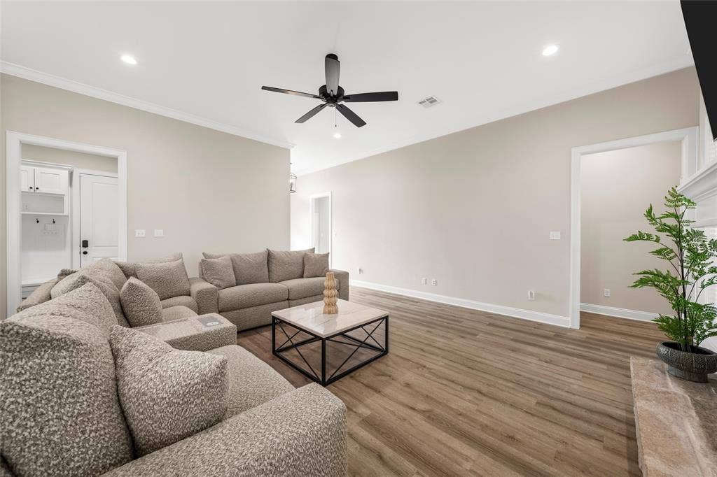 10201 Castleberry Lane, Waco, TX 76712 Expansive living area featuring vaulted ceilings, recessed lighting, a modern ceiling fan, wood-finish flooring, and a built-in mudroom bench with cabinetry