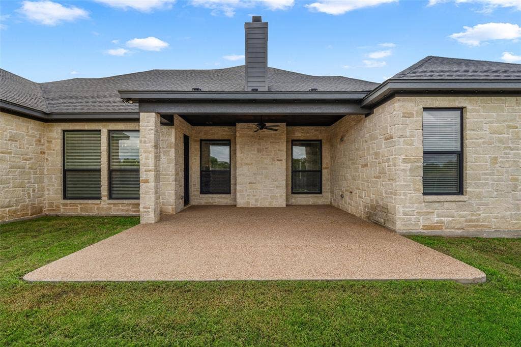 10201 Castleberry Lane, Waco, TX 76712 Expansive covered patio with a textured concrete surface, stone exterior, and a built-in ceiling fan