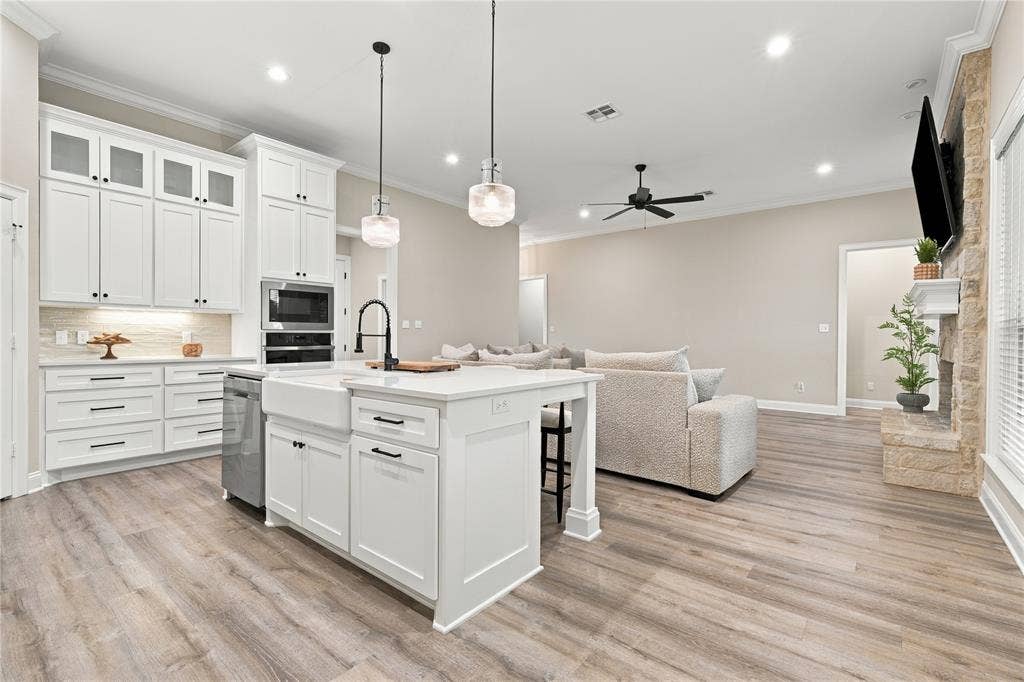 10201 Castleberry Lane, Waco, TX 76712 Gourmet kitchen with white shaker cabinetry, an apron-front sink, and built-in appliances