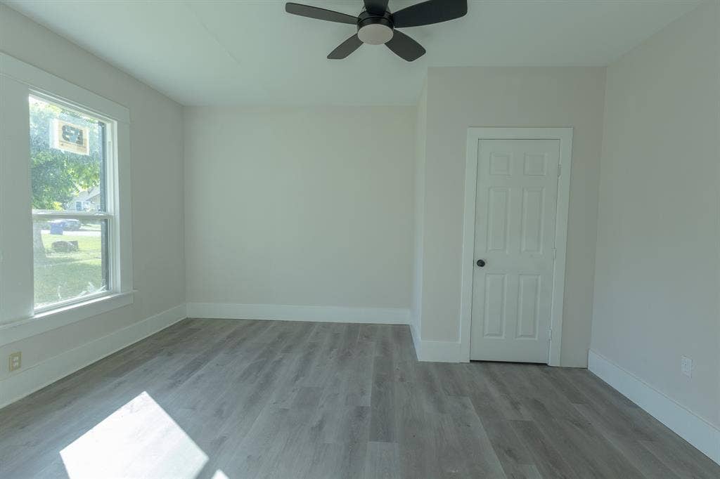 1702 Ethel Avenue, Waco, TX 76707 Light-toned walls, wood-finish flooring, white trim, a double-hung window, and a ceiling fan