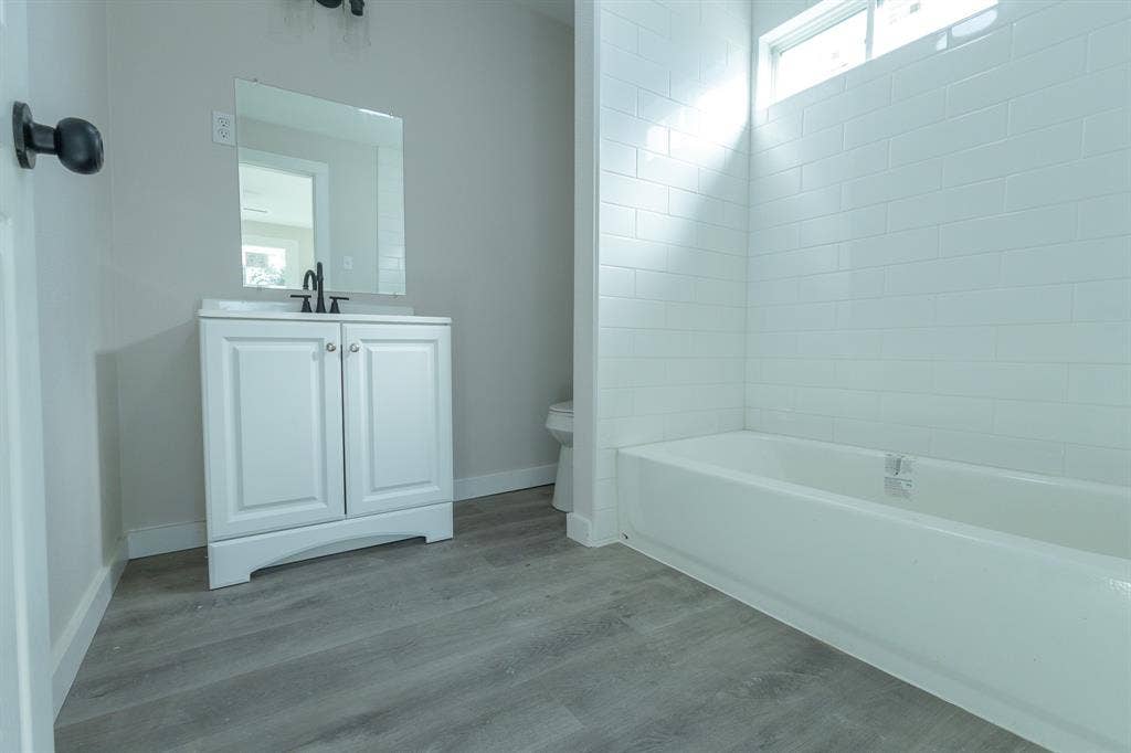 1702 Ethel Avenue, Waco, TX 76707 White vanity with a rectangular sink, matte black faucet, and matching mirror