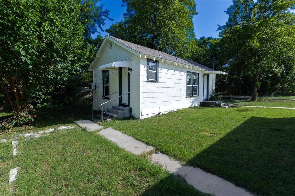 1702 Ethel Avenue, Waco, TX 76707 White siding exterior with dark trim windows, front porch with awning, and mature trees