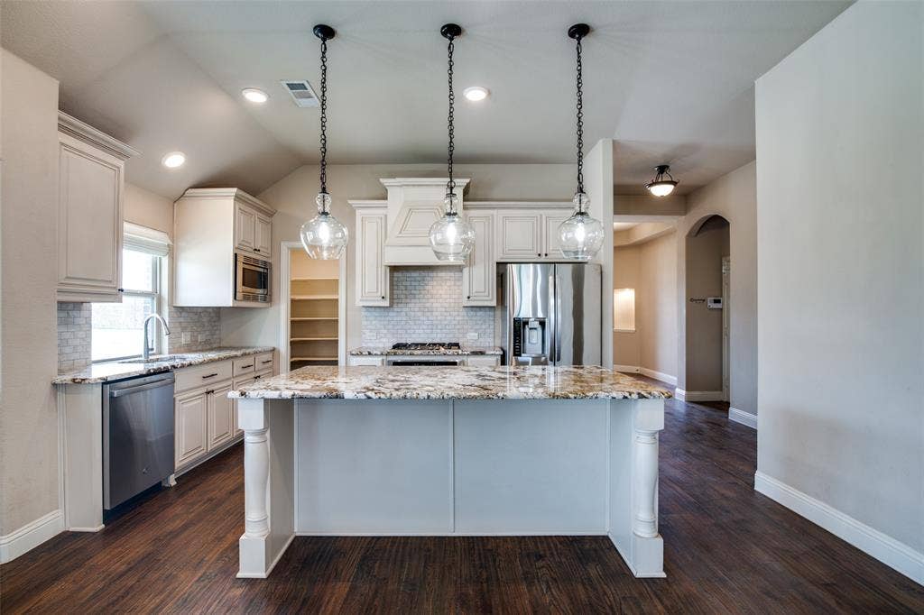 1813 Chadwick Lane, Forney, TX 75126 Kitchen featuring a central island with a granite countertop, white cabinetry, a built-in stainless steel microwave, and wood-finish flooring