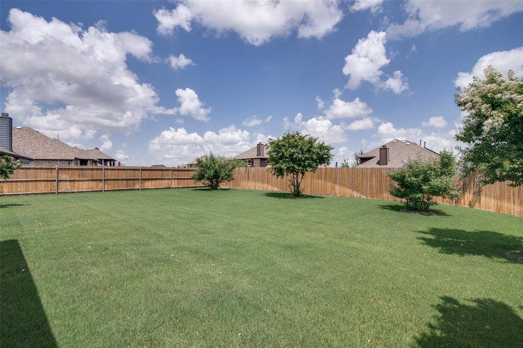 1813 Chadwick Lane, Forney, TX 75126 Expansive backyard with a lush lawn, privacy fencing, and mature trees