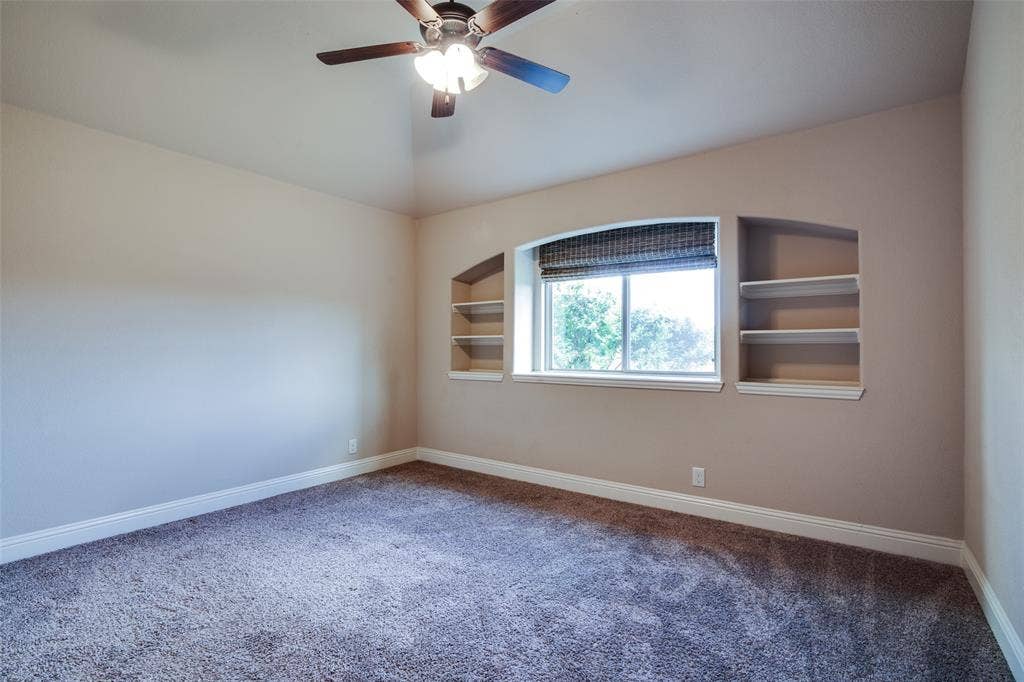 1813 Chadwick Lane, Forney, TX 75126 Recessed window with arched detail, built-in shelving, ceiling fan with integrated lighting, and wall-to-wall carpeting