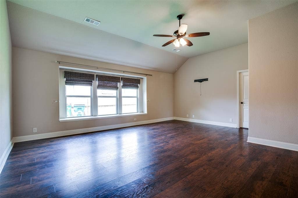 1813 Chadwick Lane, Forney, TX 75126 Vaulted ceiling with a ceiling fan, wood-finish flooring, and multiple windows with blinds