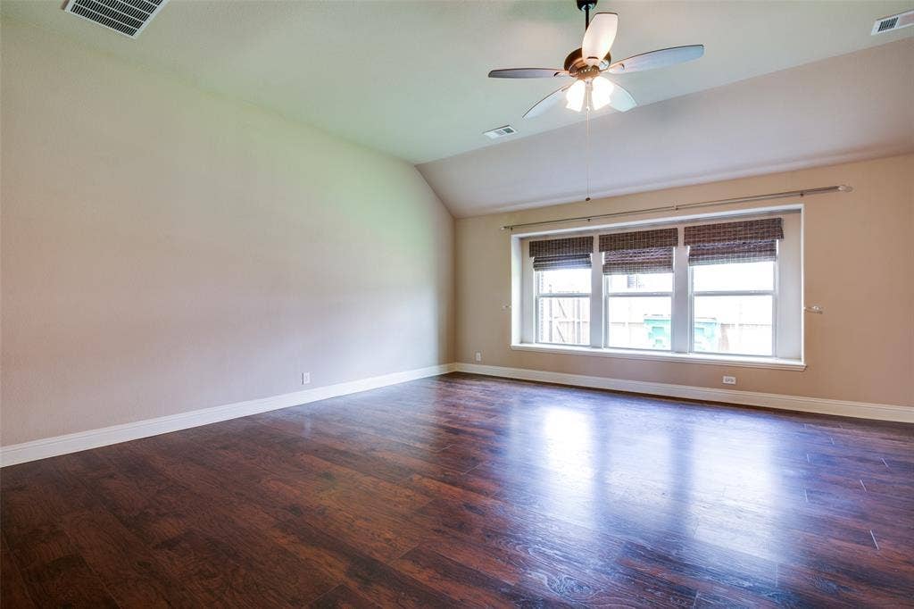 1813 Chadwick Lane, Forney, TX 75126 Expansive room featuring wood-finish flooring, multiple windows, a ceiling fan with integrated lighting, and a neutral wall color